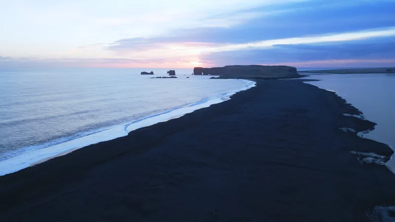 Aerial View Black Sand Beach With Mountains Big Stones Iceland Beautiful Natural Scenery Reynisfjara Beach Icelandic Landscape With Atlantic Ocean Coastline Slow Motion