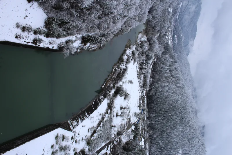 Aerial View River Surrounded By Snowy Mountains Trees Winter