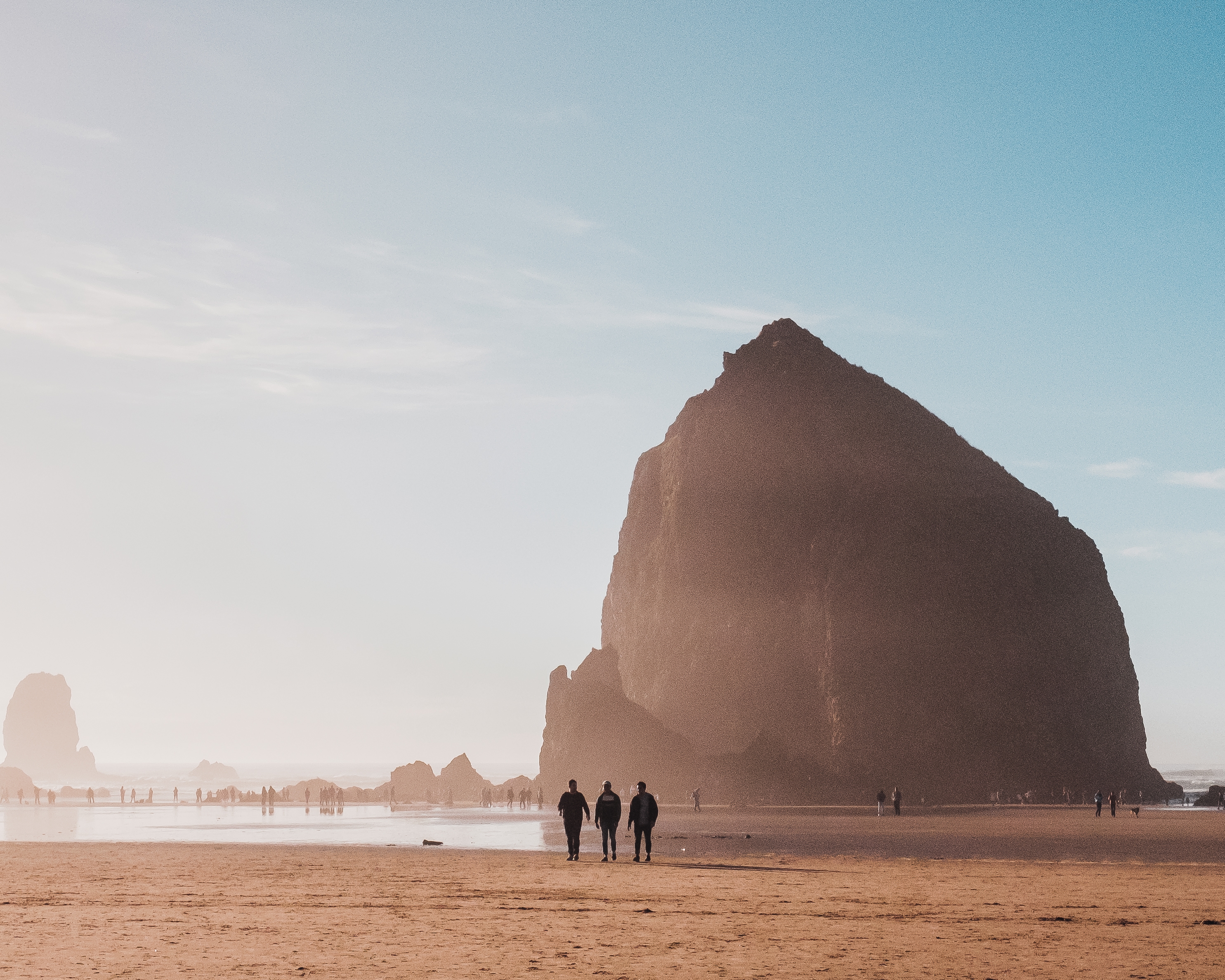 Beautiful Shot People Walking Beach Shore With Rock Distance Daytime