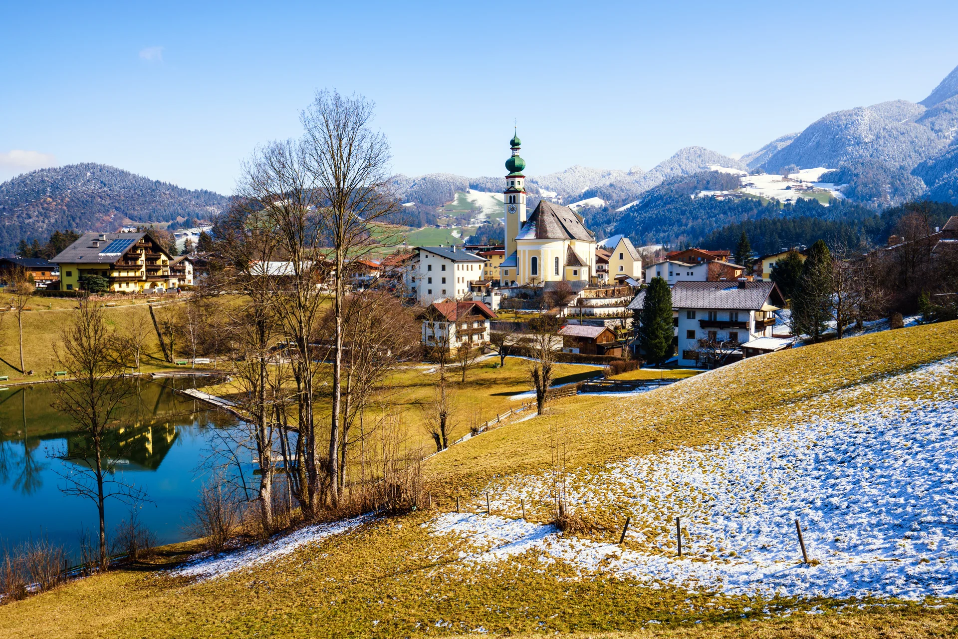 Beautiful Shot Small Village Surrounded By Lake Snowy Hills. Nature wallpaper. 5848×3899px. Free download for personal use.