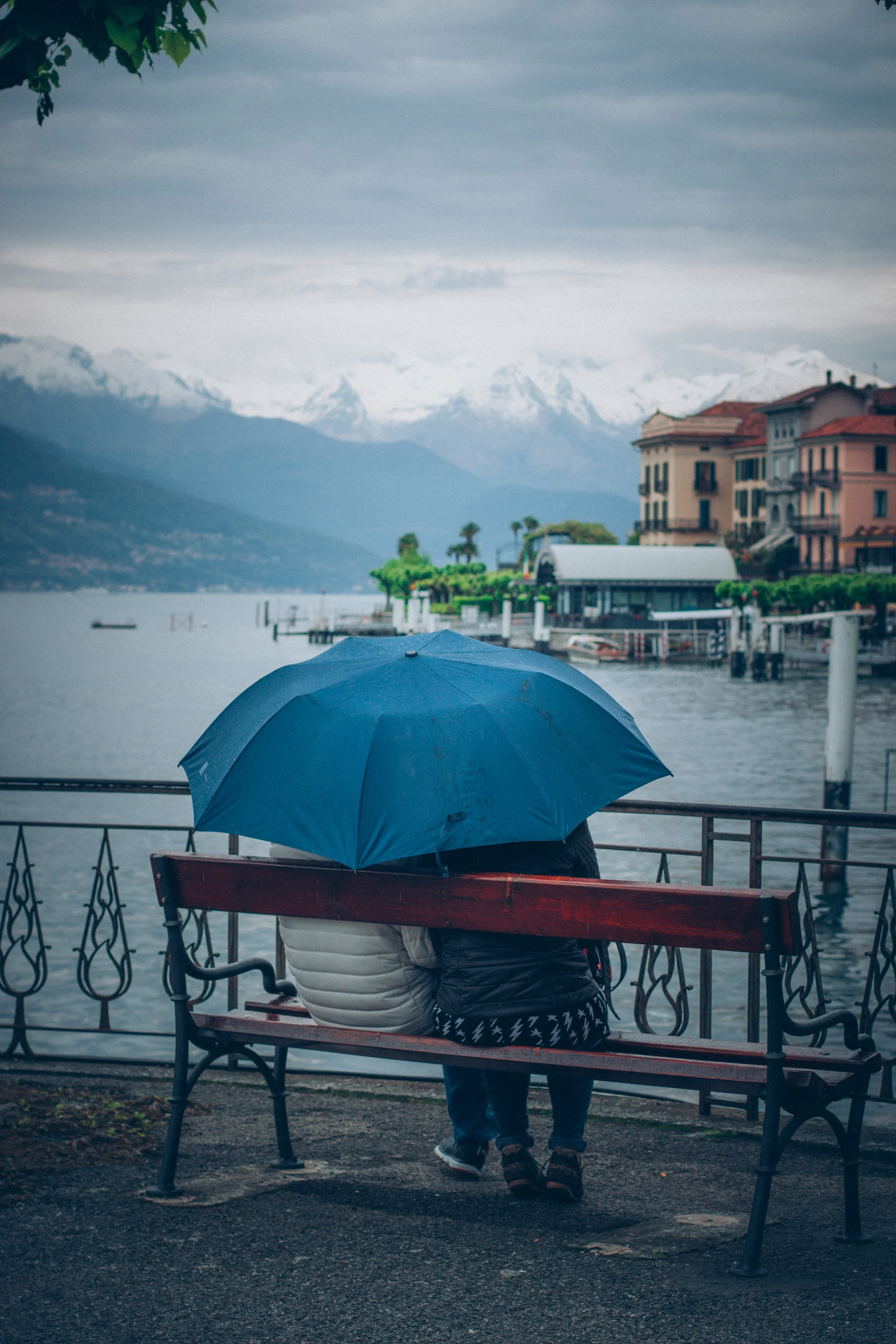 Couple Sitting Bench By Lake Blue Umbrella. Nature wallpaper. 3168×4752px. Free download for personal use.