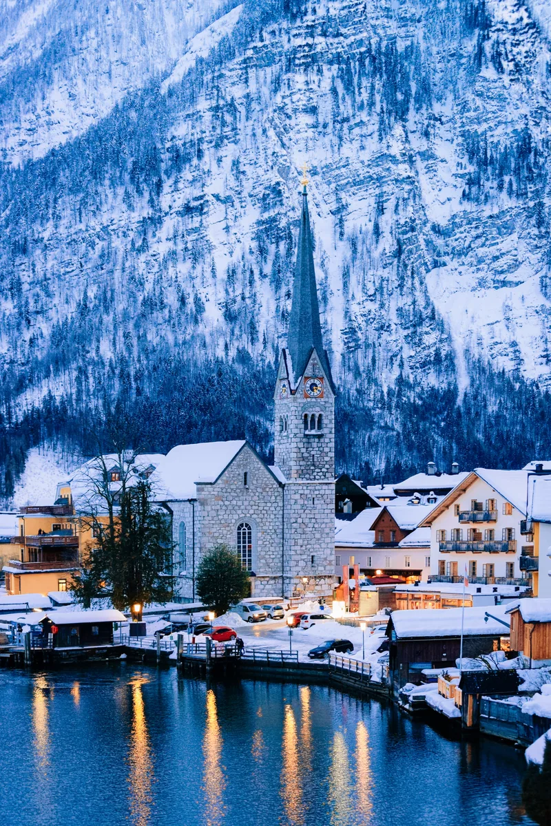 Hallstatt Near Salzburg Austria Europe Winter Salzkammergut Travel Austrian City With Lake Evening Alpine Land With Snow View Village Near Alps Mountains With Beautiful Church