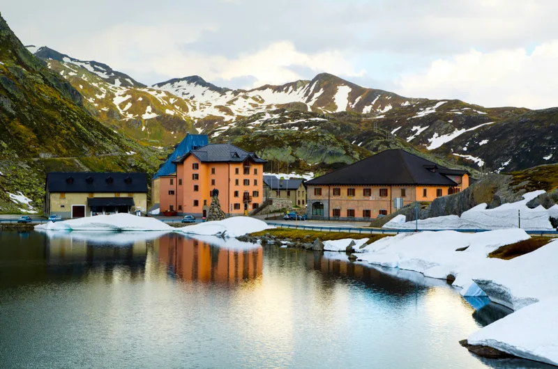 High Angle Shot Some Houses By Lake Near Snow Covered Mountains