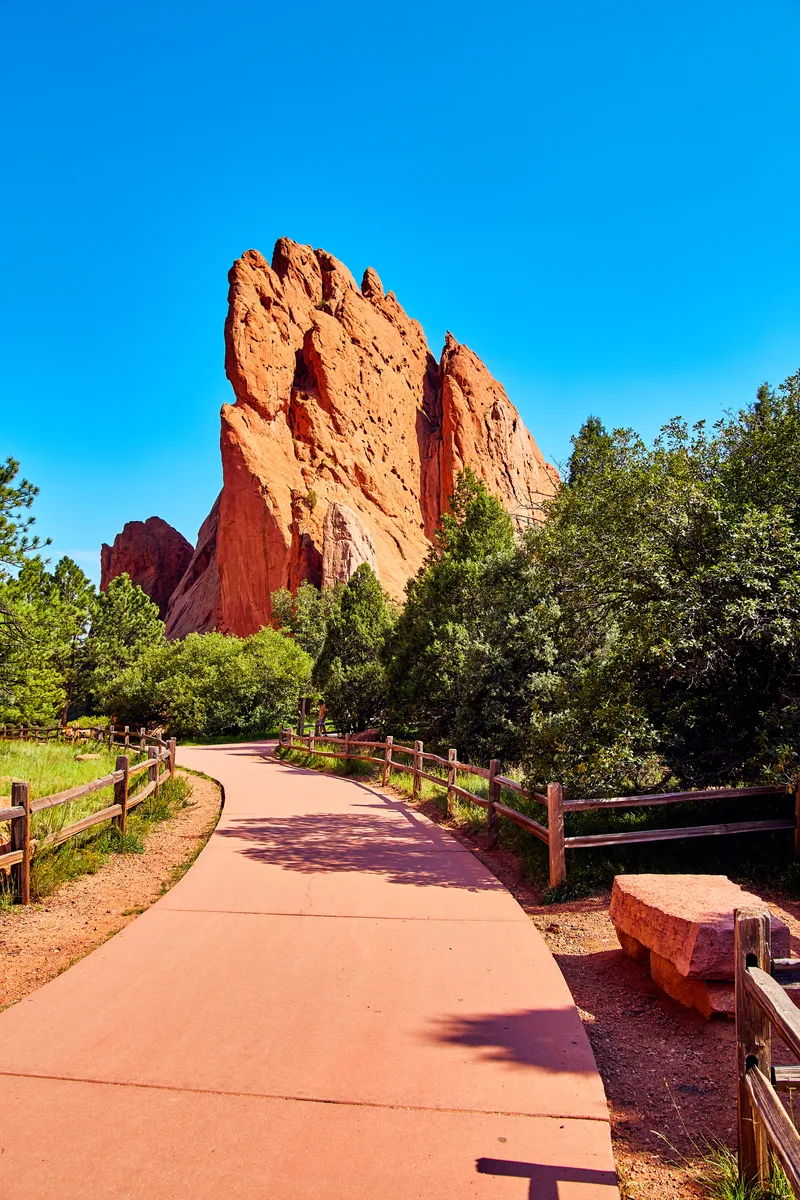 Image Paved Park Path With Stone Bench Background Large Red Pillar Rock