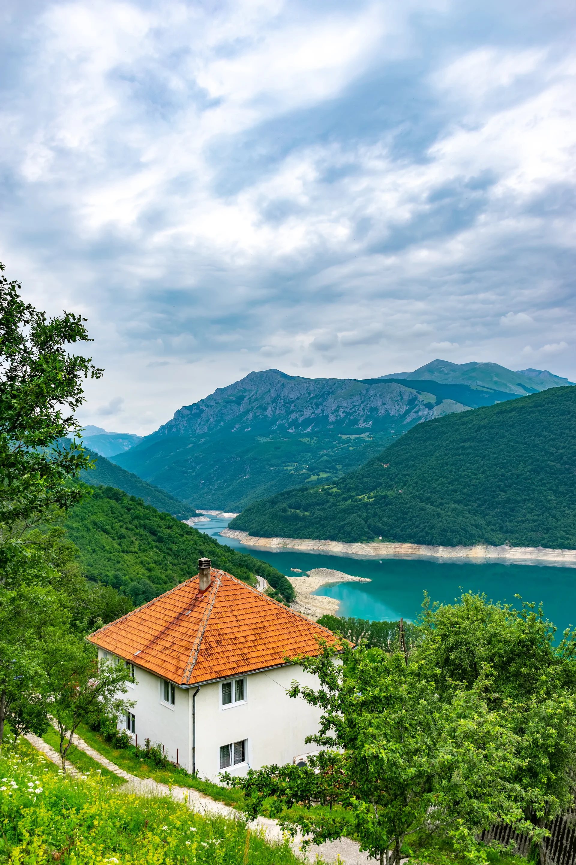 Lonely House Stands Shore Mountain Lake. Nature wallpaper. 4000×6000px. Free download for personal use.