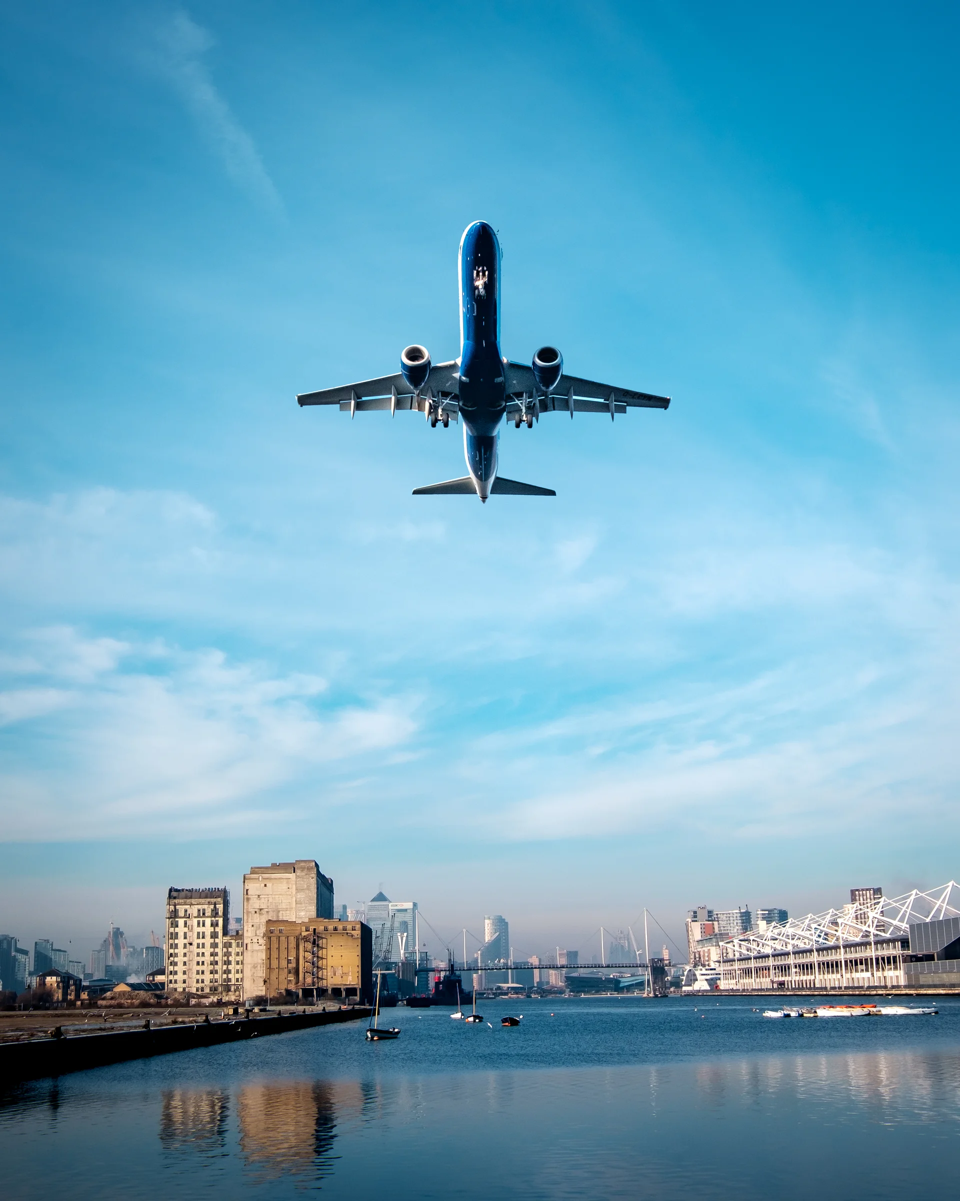 Low Angle View Airplane Flying City Against Sky. Aerial wallpaper. 3203×4004px. Free download for personal use.