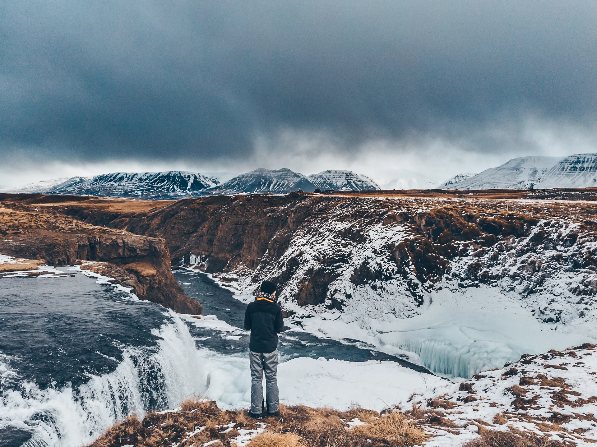 Rear View Man Standing Waterfall Against Sky. Nature wallpaper. 3654×2737px. Free download for personal use.