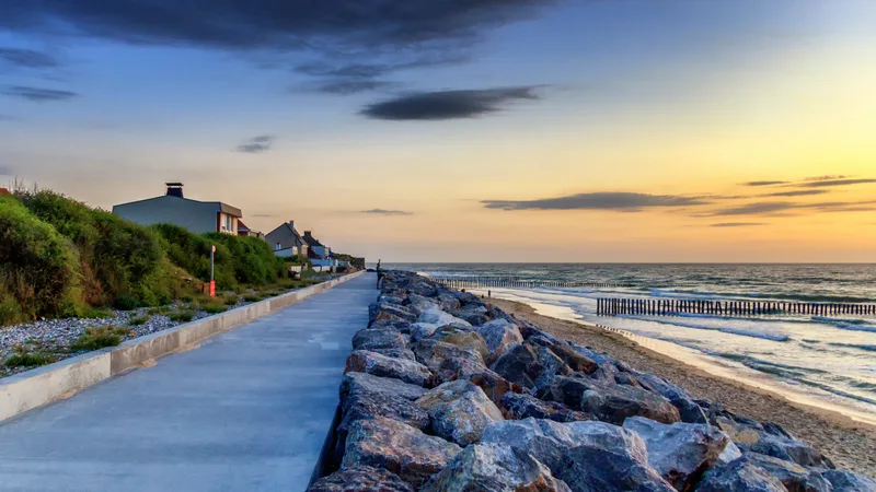 Scenic View Sea By Buildings Against Sky Sunset