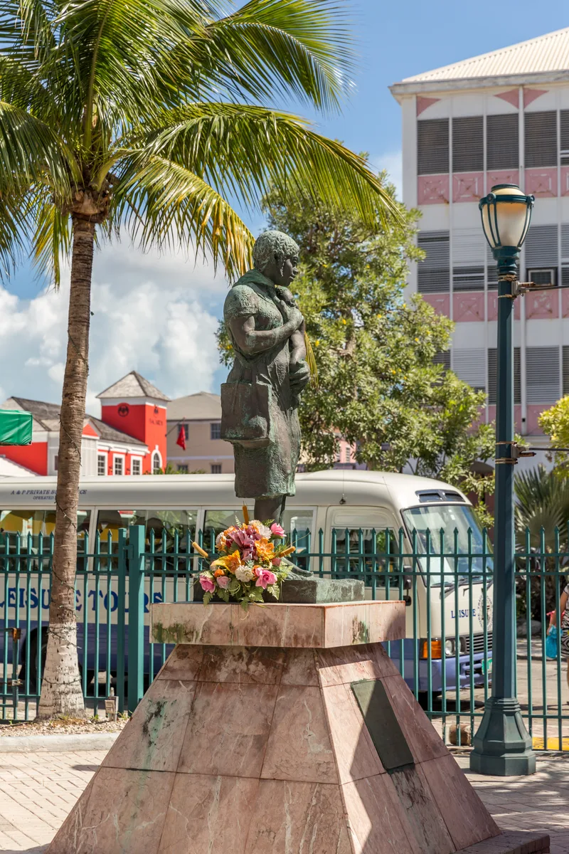 Statue By Palm Trees Buildings Against Sky