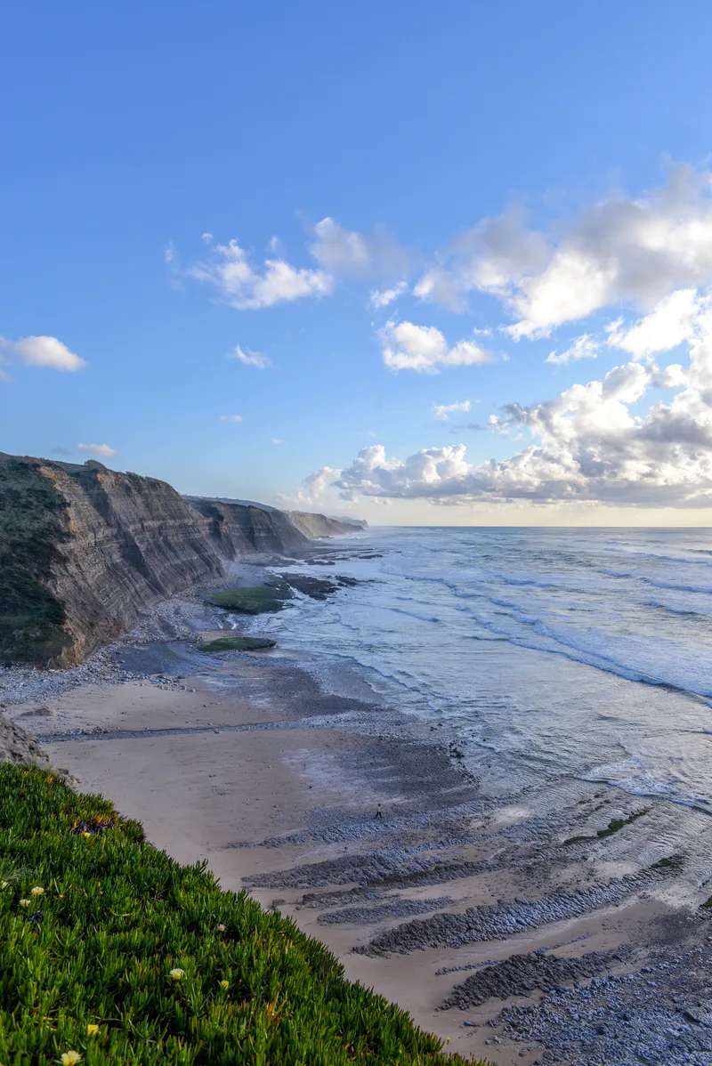 Vertical Picture Beach Surrounded By Sea Cliffs Sunlight Cloudy Sky