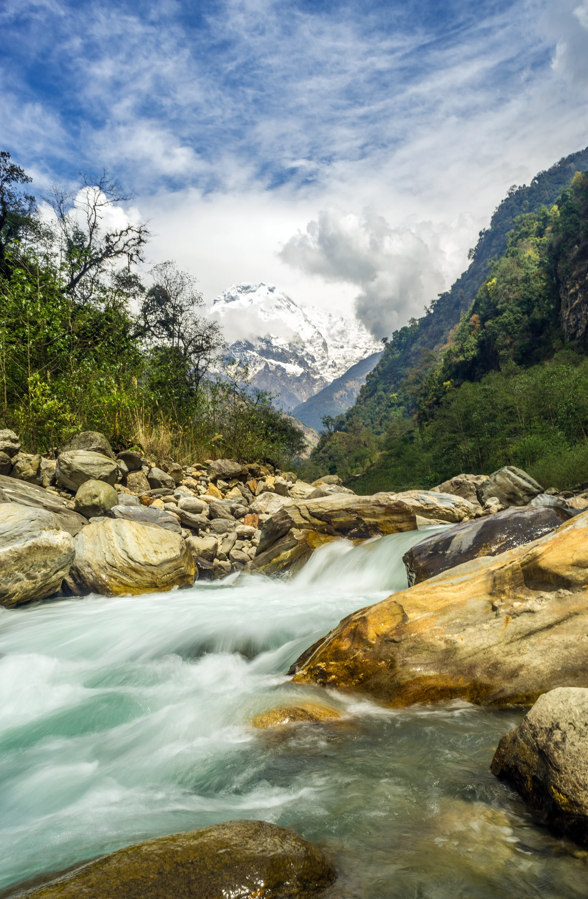Vertical Shot Rapid River Crashing Rocks With Mountains. Nature wallpaper. 3439×5256px. Free download for personal use.