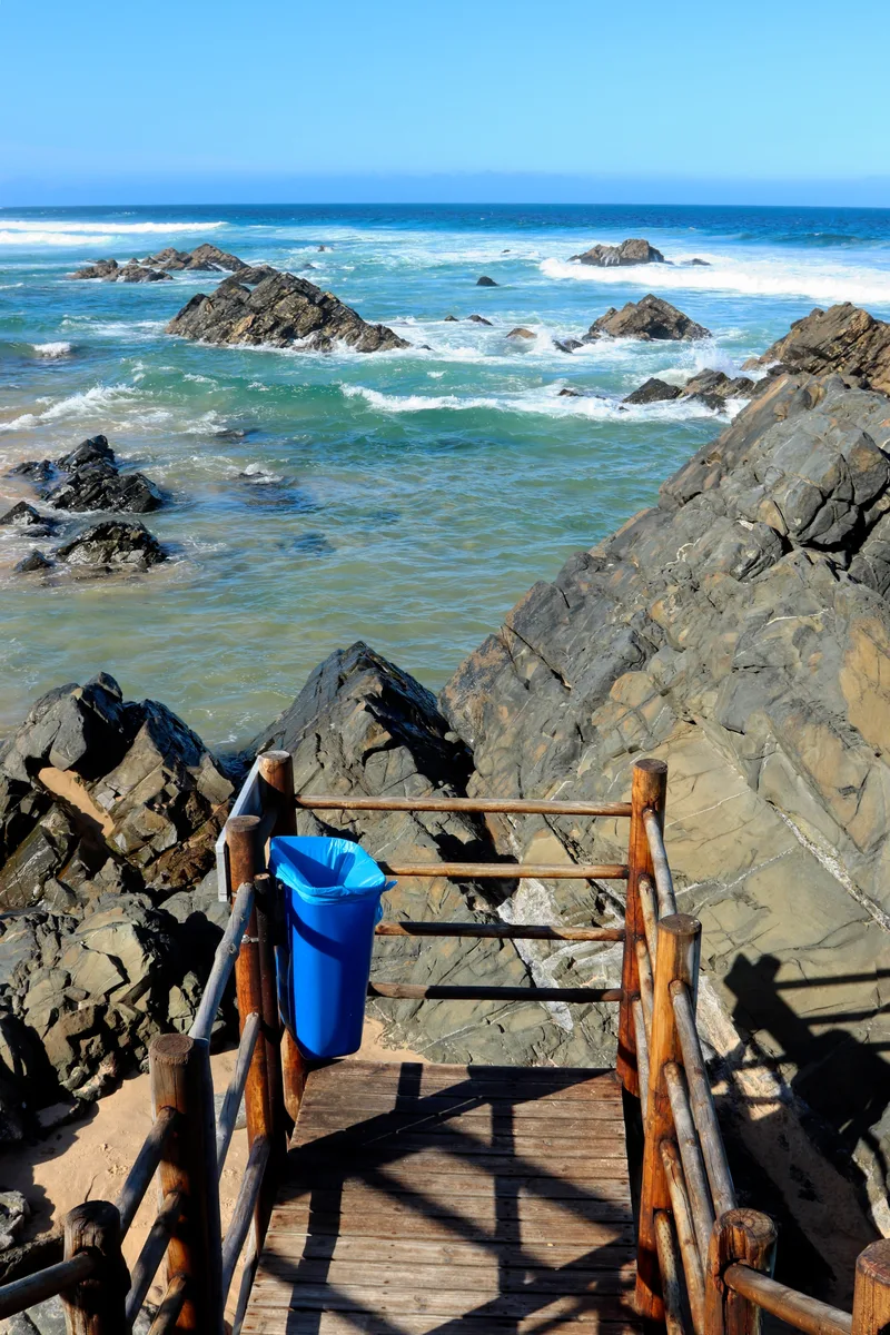 Vertical Shot Sea With Waves Hitting Rocks Blue Sky