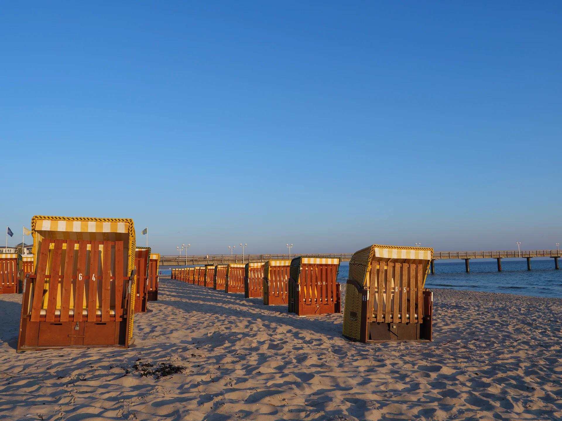 Wooden Chairs Beach Against Clear Blue Sky. Nature wallpaper. 5022×3767px. Free download for personal use.