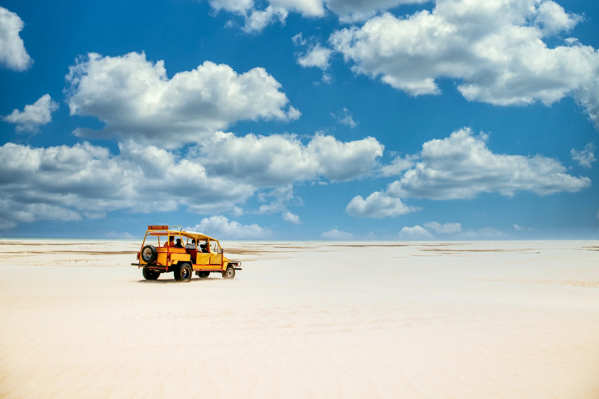 Yellow Truck Riding Sandy Ground Cloudy Blue Sky. Nature wallpaper. 5676×3784px. Free download for personal use.